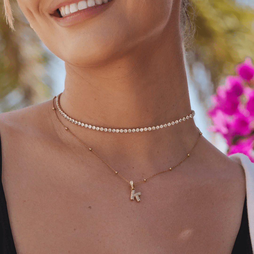 name necklace in gold with initial letter pendant worn by woman – personalised gift idea UK