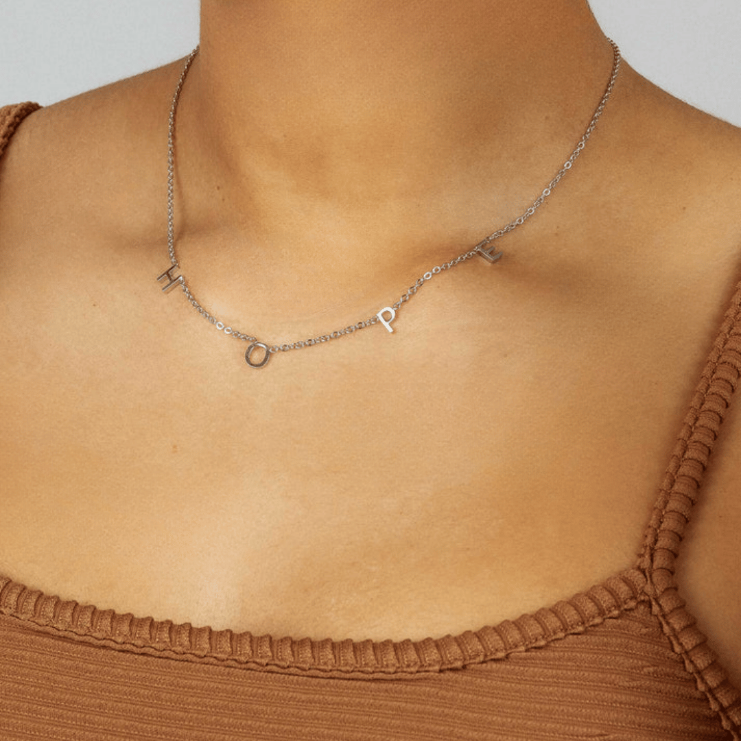 personalised initial necklace layered look – worn by woman
