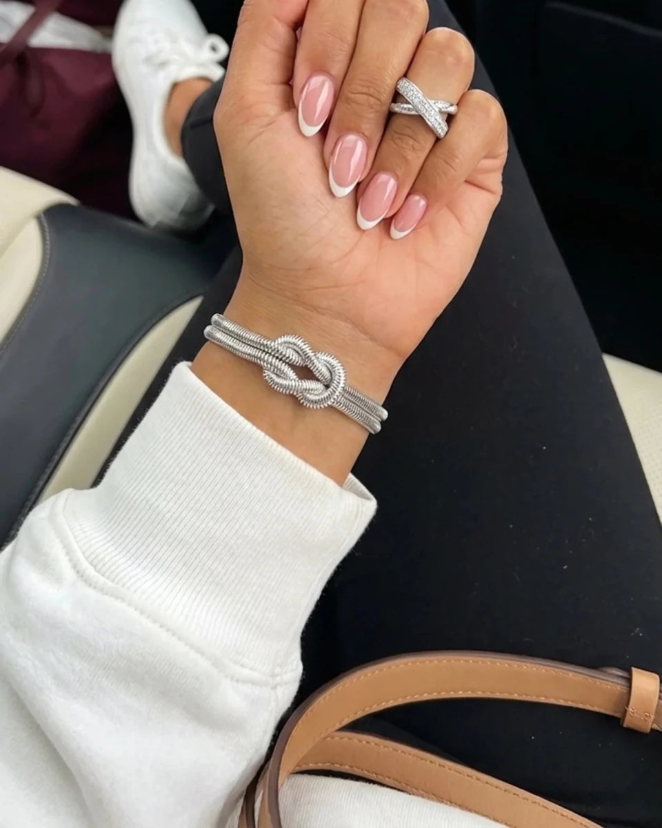 Woman wearing silver double knot herringbone bracelet with crossover ring - Moonela waterproof jewellery