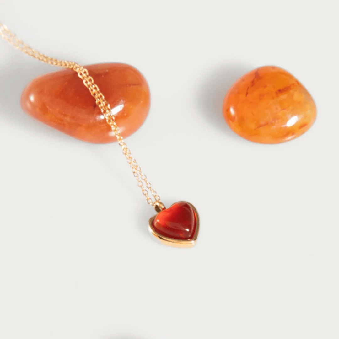 flat lay of carnelian pendant and matching gemstone – vitality and passion