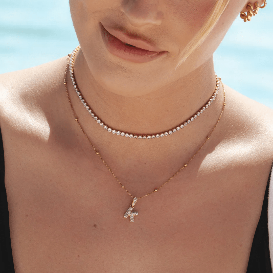 delicate gold tennis necklace on tanned skin – dainty chain with zircon stones
